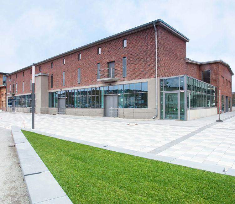 Backsteinbau mit Glasfassade und moderner Architektur im Hintergrund