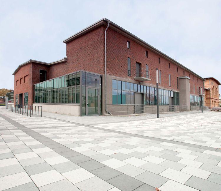 Seitenansicht eines Ziegelgebäudes mit modernen Fensterfronten