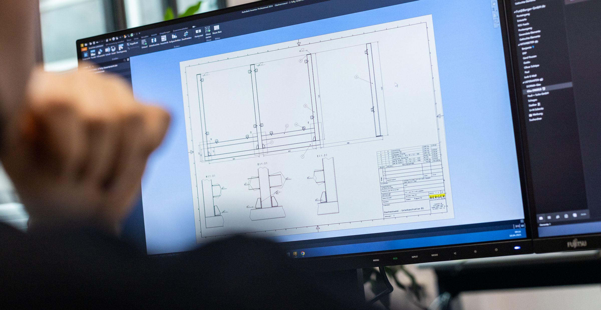 Ein Mann betrachtet am Computer eine technische Zeichnung in AutoCAD, die auf einem Monitor angezeigt wird. Die Zeichnung zeigt Ansichten und Maße eines Konstruktionsbauteils.          ChatGPT fragen